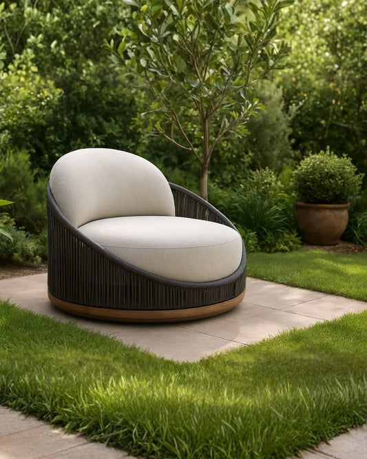 Modern outdoor chair with white cushion on a patio surrounded by greenery