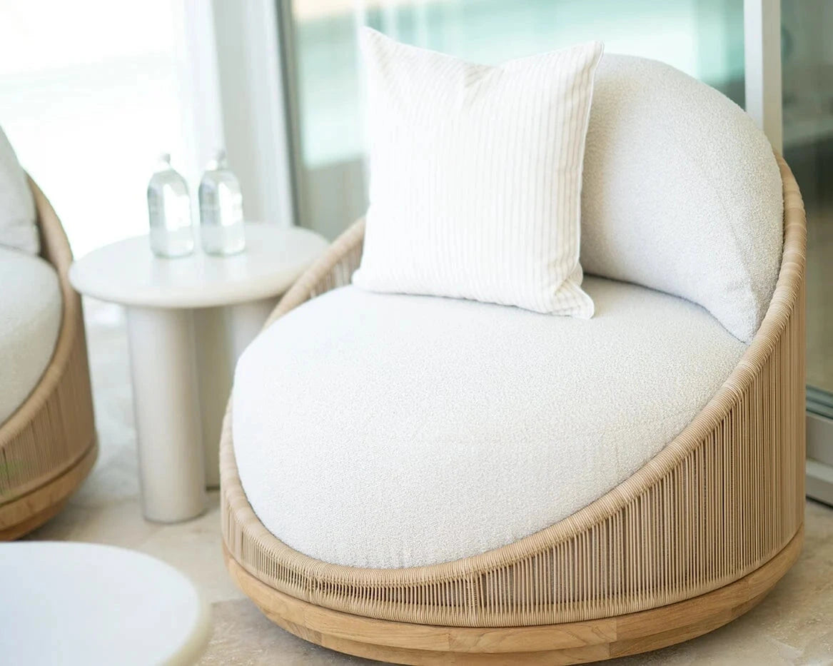 Round wicker chair with white cushion in a modern indoor setting