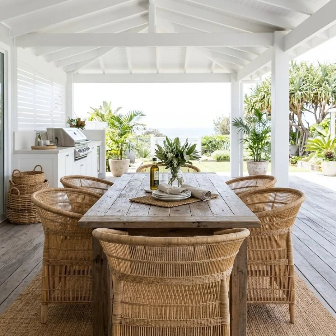 Outdoor dining area with wooden table and wicker chairs on a patio.