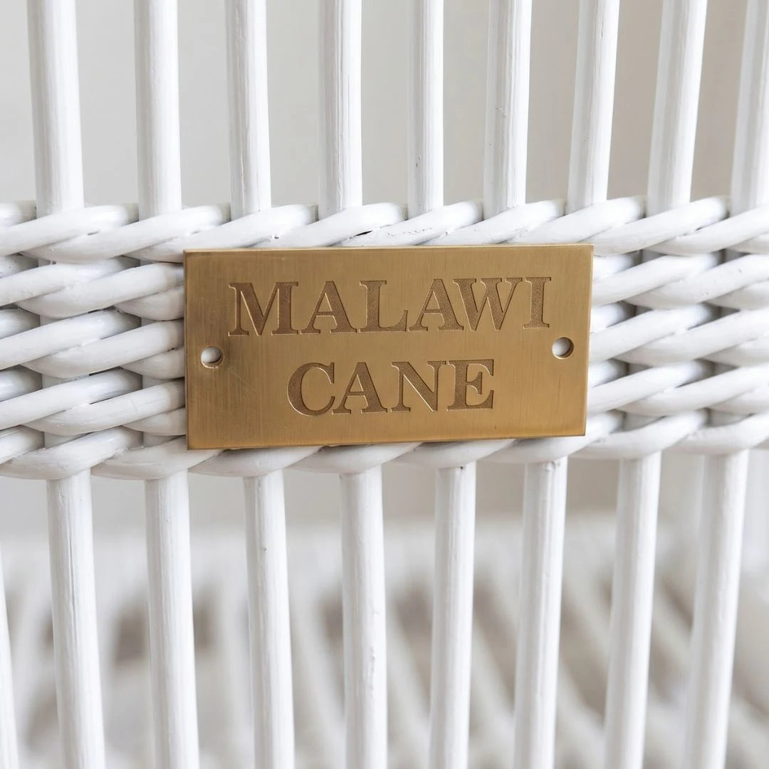 Brass tag with 'MALAWI CANE' on a white woven background