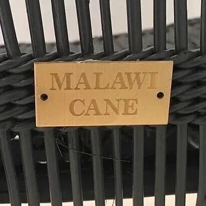Black woven basket with a 'Malawi Cane' label on a neutral background
