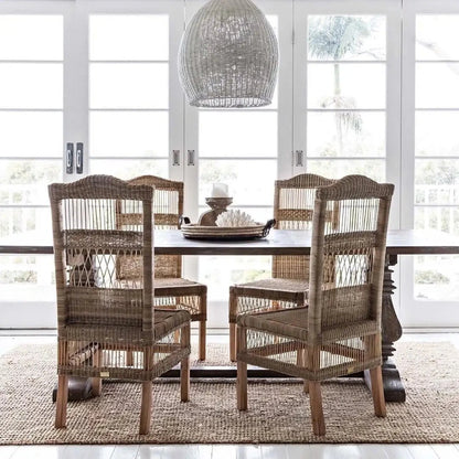Dining room with wooden table and chairs in a bright room with large windows.