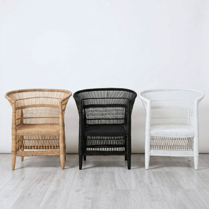 Three wicker chairs in brown, black, and white against a white wall.