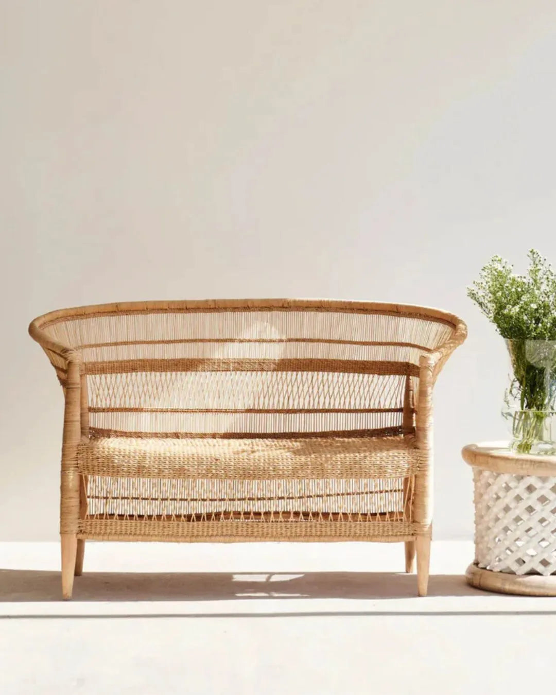 Wicker chair with a plant on a white background