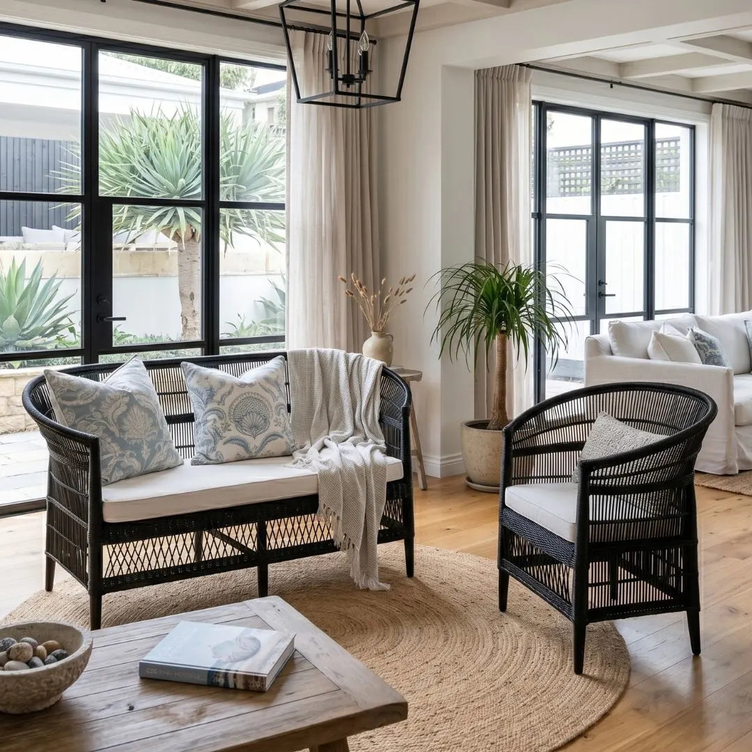Living room with black wicker furniture, white cushions, and a large window.