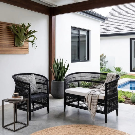Black wicker outdoor furniture set with cushions in a modern patio setting.