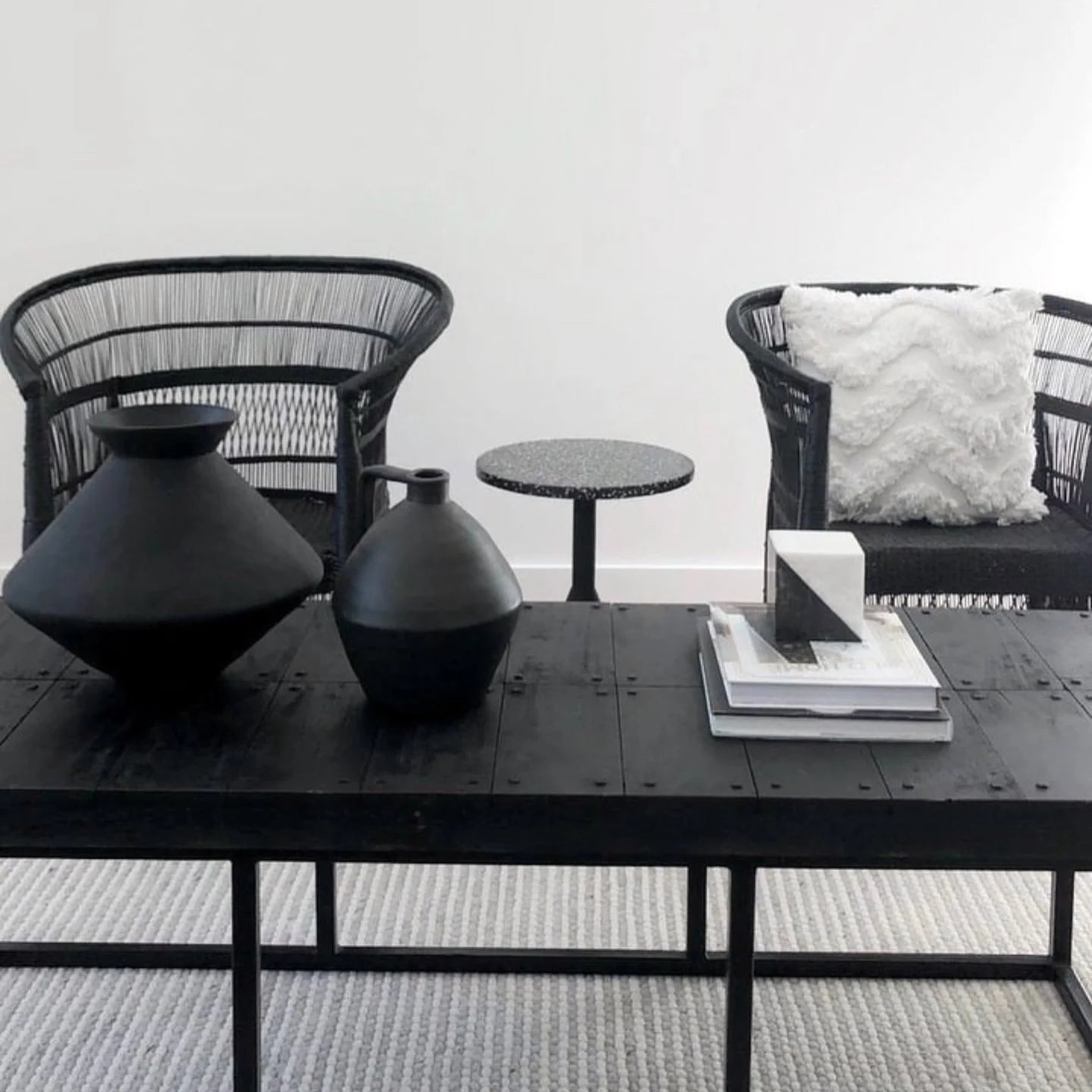 Modern furniture set with black table, chairs, and decorative items.