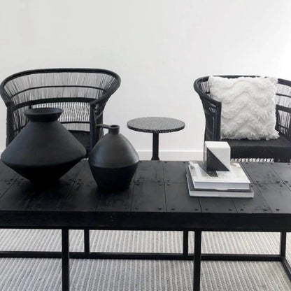 Modern furniture set with black table, chairs, and decorative items.