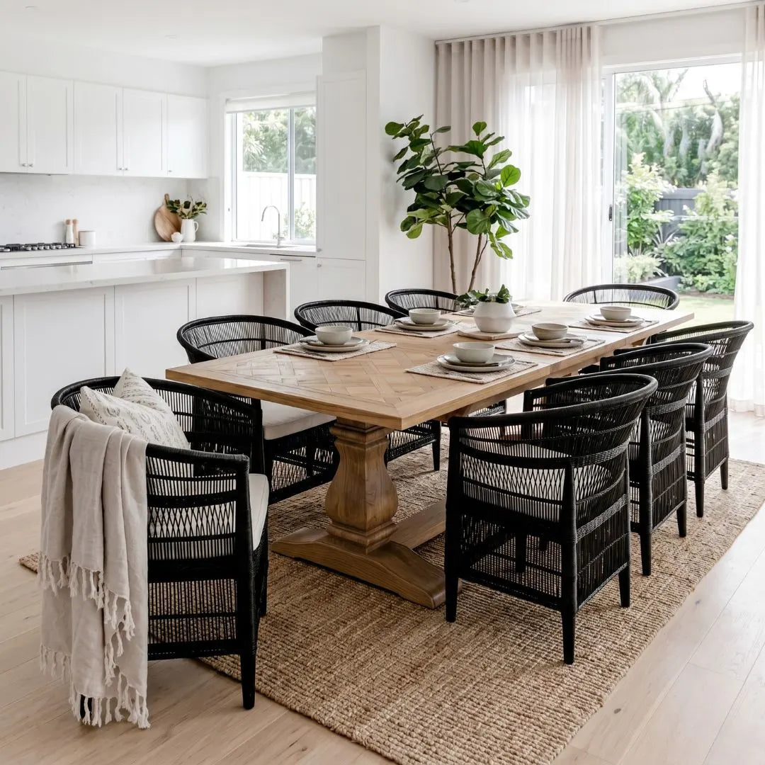 Dining room with a wooden table and black chairs on a wooden floor.