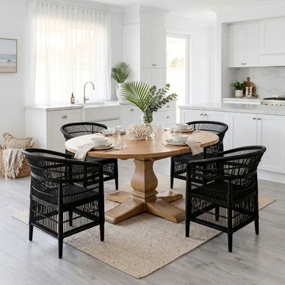 Dining area with wooden table and black chairs in a bright kitchen.