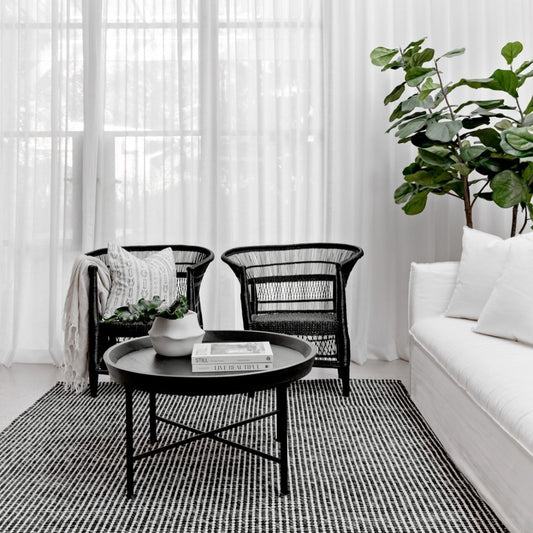 Modern living room with black wicker chairs, a white sofa, and a coffee table.