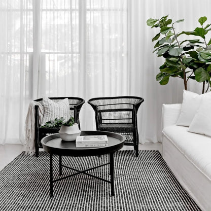Modern living room with black Malawi Cane chairs, a white sofa, and a coffee table.