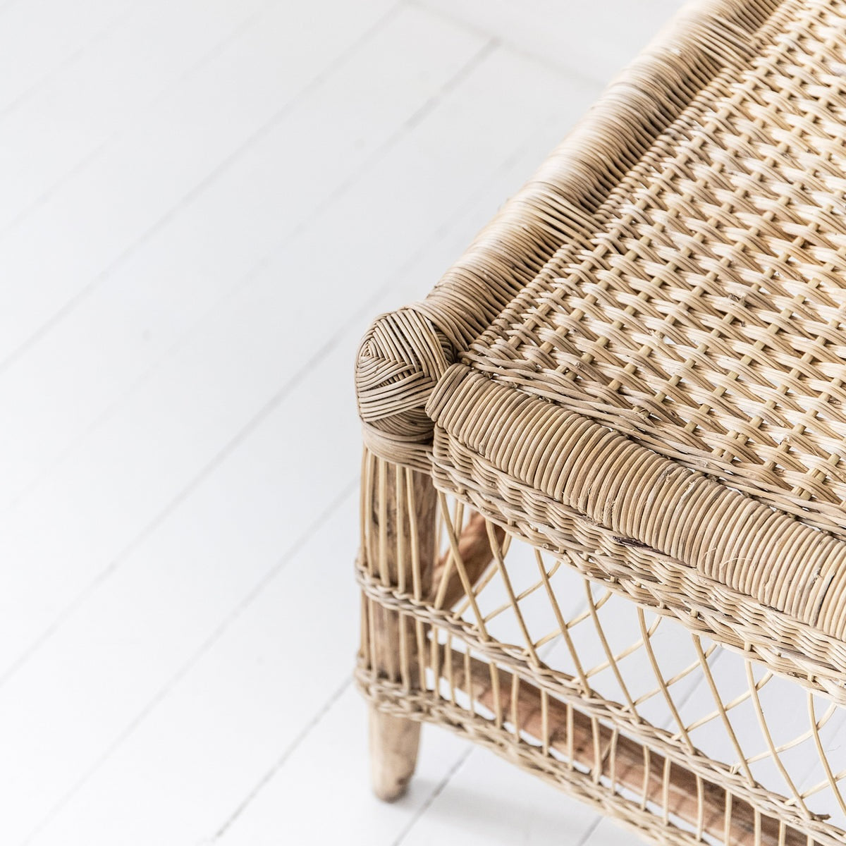 Close-up of a cane coffee table with a white floor background