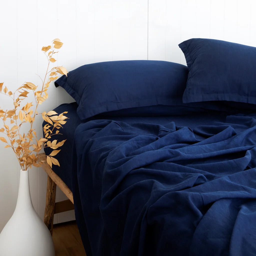 Navy blue bedding set on a bed with decorative elements.