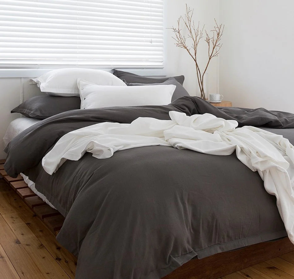 Bed with gray and white bedding in a bedroom setting
