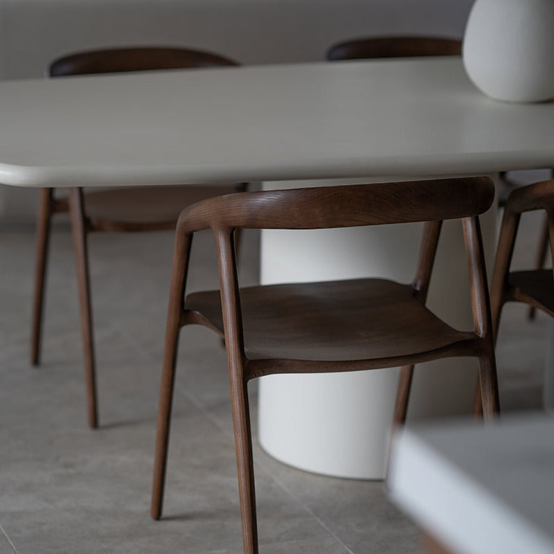 Dining area with wooden chairs and a white table.