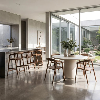 Modern kitchen with a dining area featuring a white round table and wooden chairs.