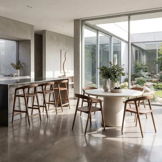 Modern kitchen with a dining area featuring a white round table and wooden chairs.