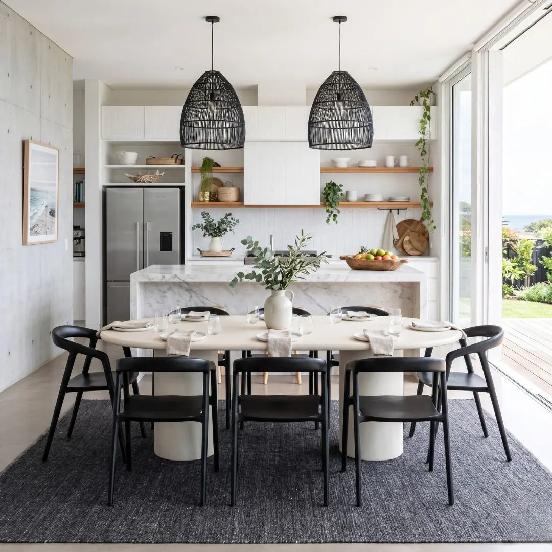 Modern kitchen with dining table and chairs, marble island, and large windows.
