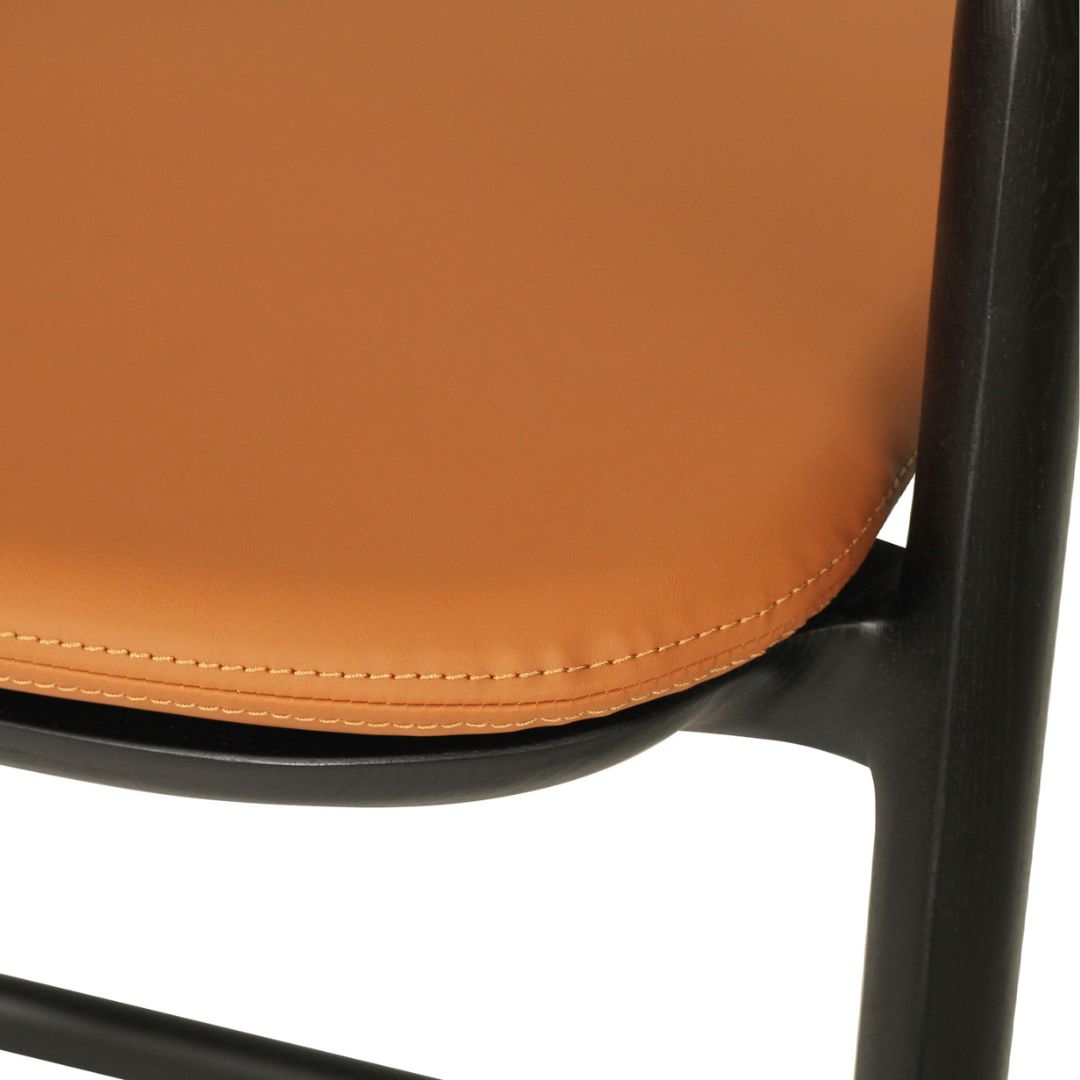 Close-up of an orange chair seat with black metal frame on a white background