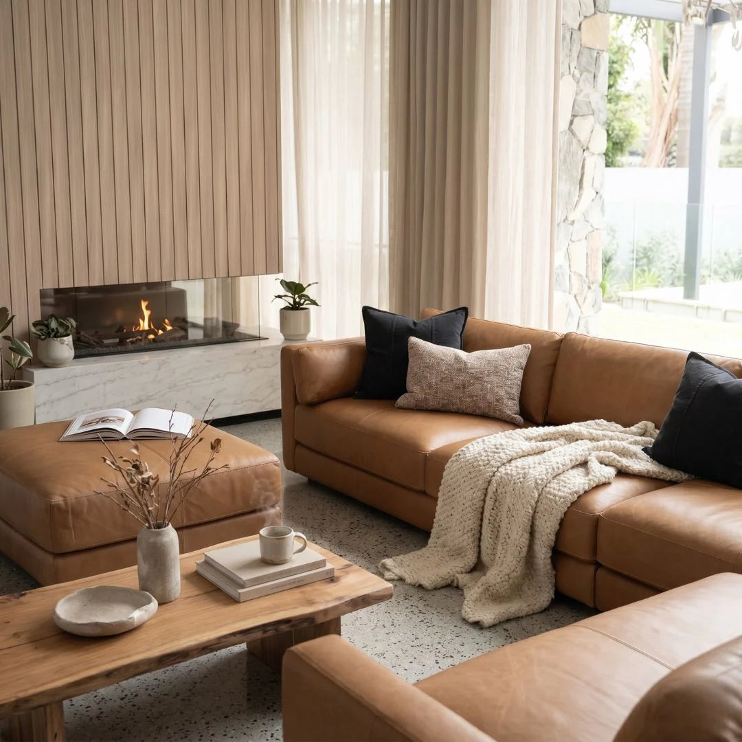 Cozy living room with brown leather sofa, wooden coffee table, and fireplace.