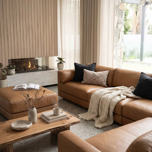 Cozy living room with brown leather sofa, wooden coffee table, and fireplace.