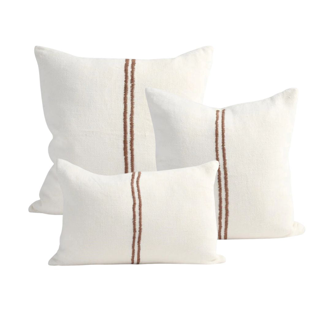 Three white pillows with brown stripes on a white background