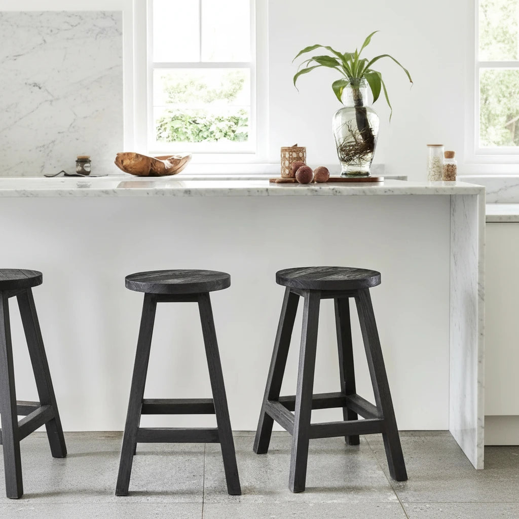 Two black stools in a kitchen setting with a white countertop and window in the background.