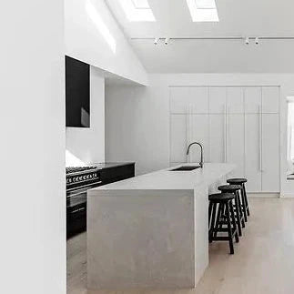 Modern kitchen and dining area with white walls and black furniture.