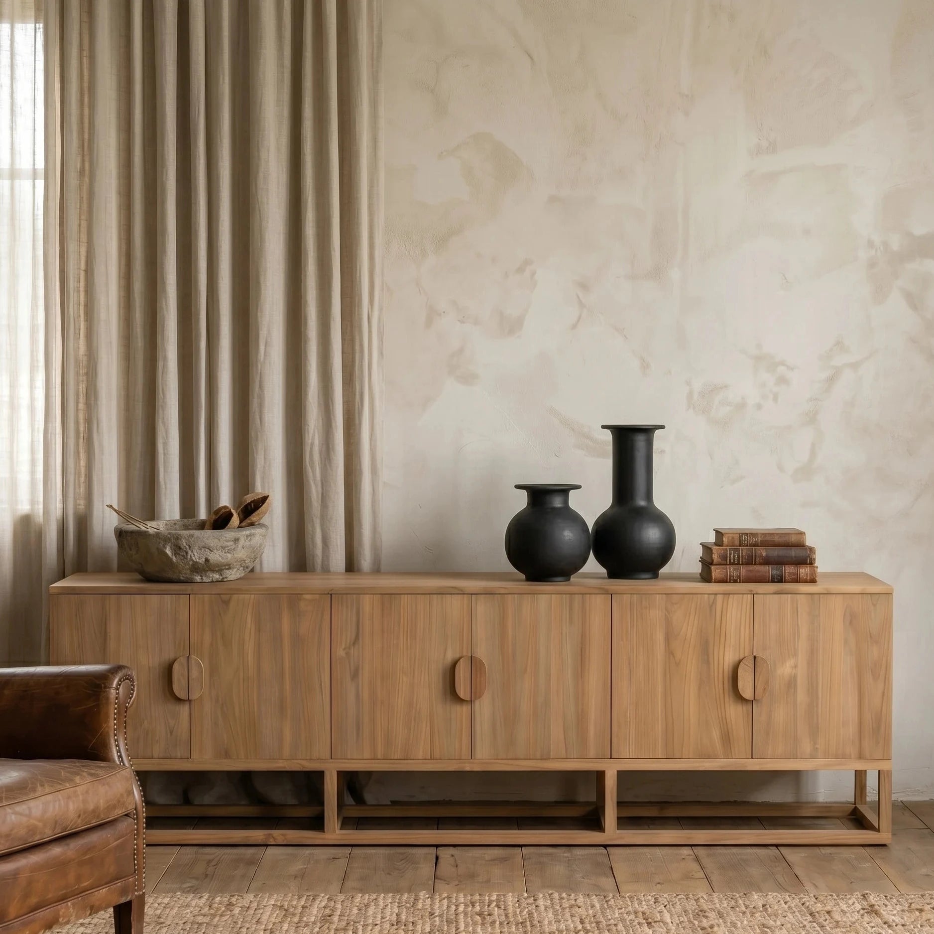 Wooden sideboard with decorative items in a room with curtains and a rug.
