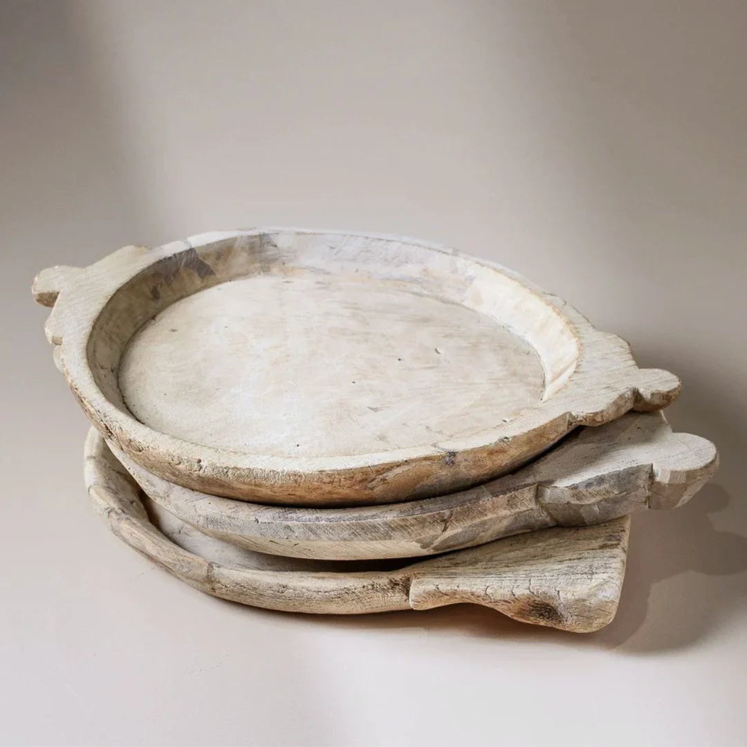 Stack of rustic wooden bowls on a neutral background