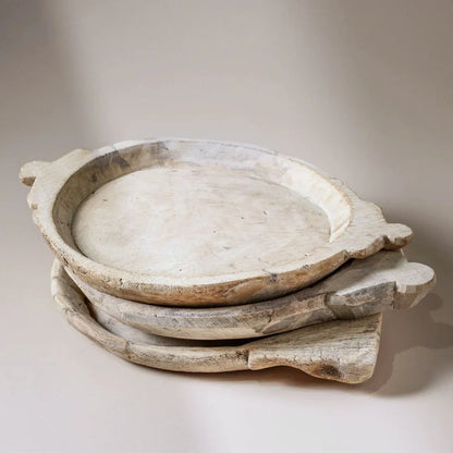 Stack of rustic wooden bowls on a neutral background