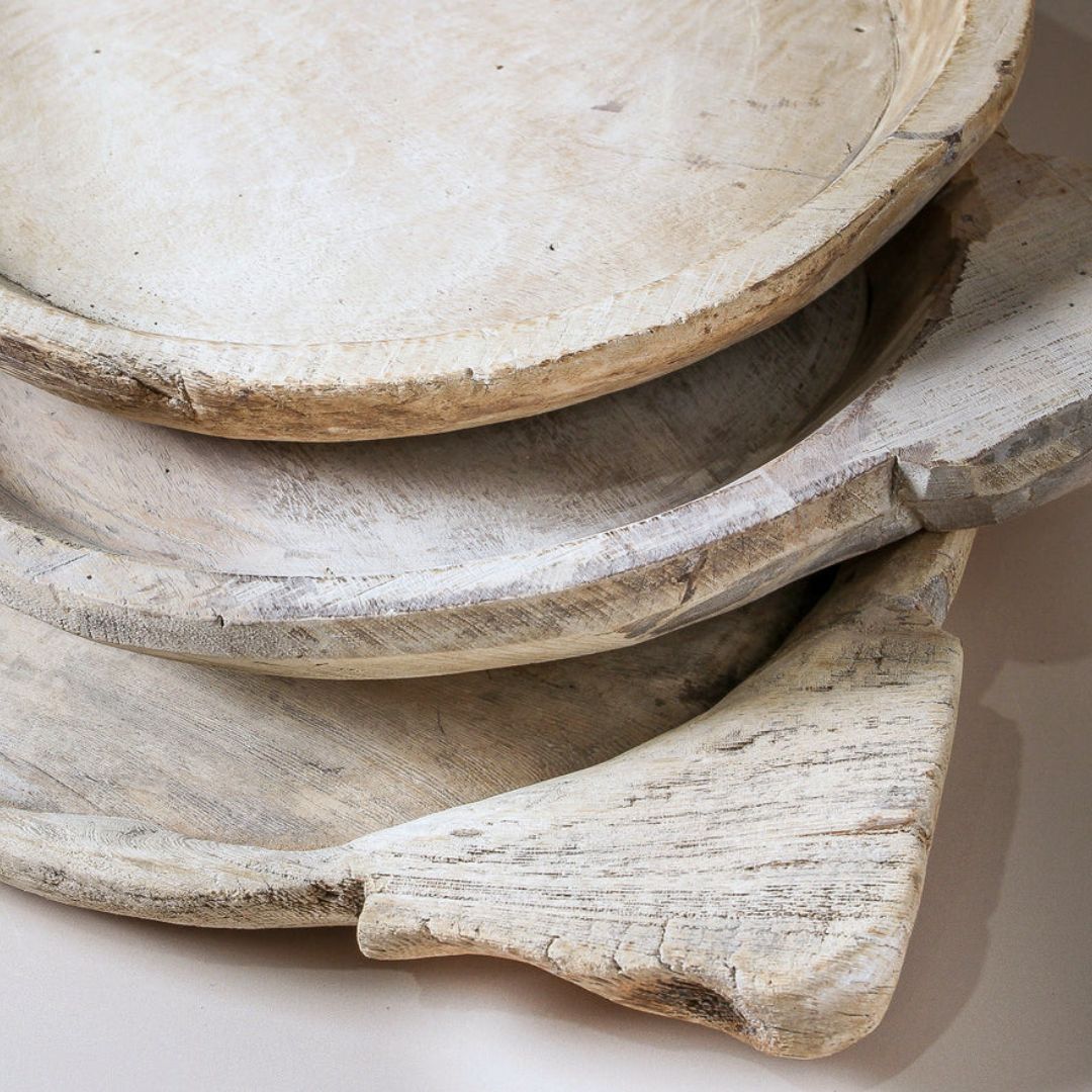 Stack of rustic wooden trays on a light background