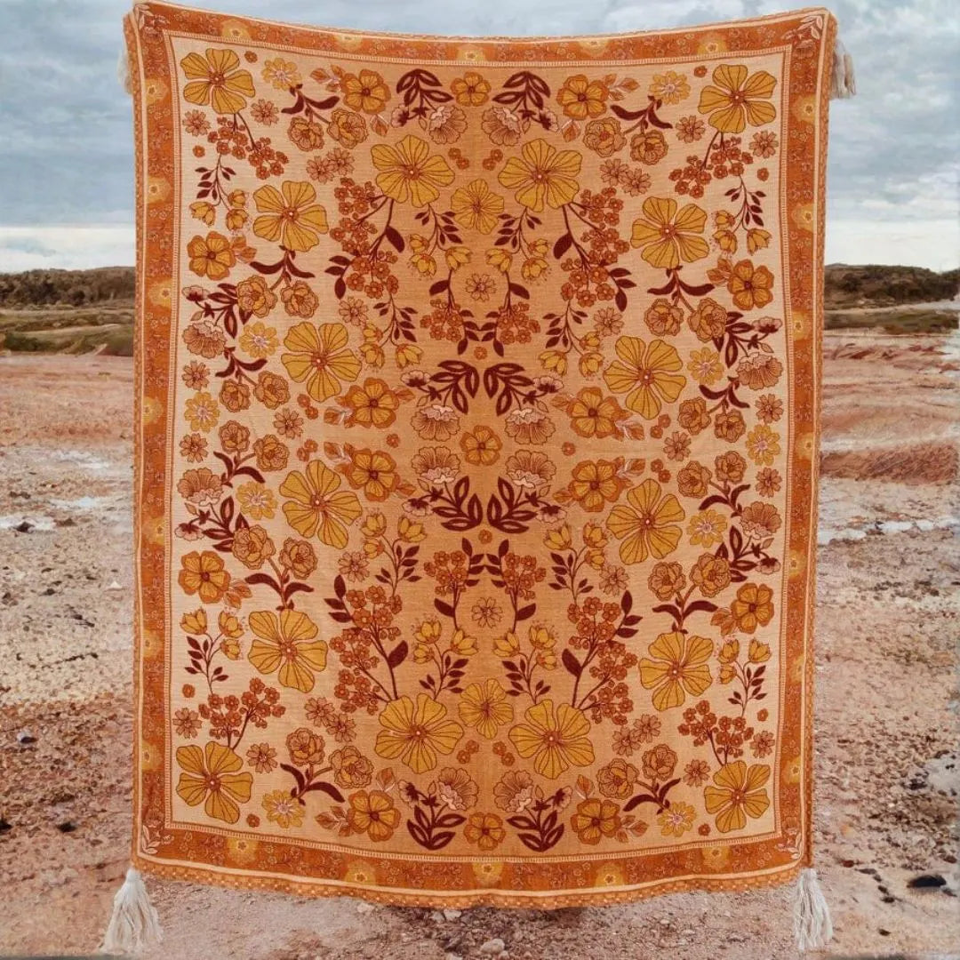 Floral patterned blanket with yellow and brown colors on a desert background