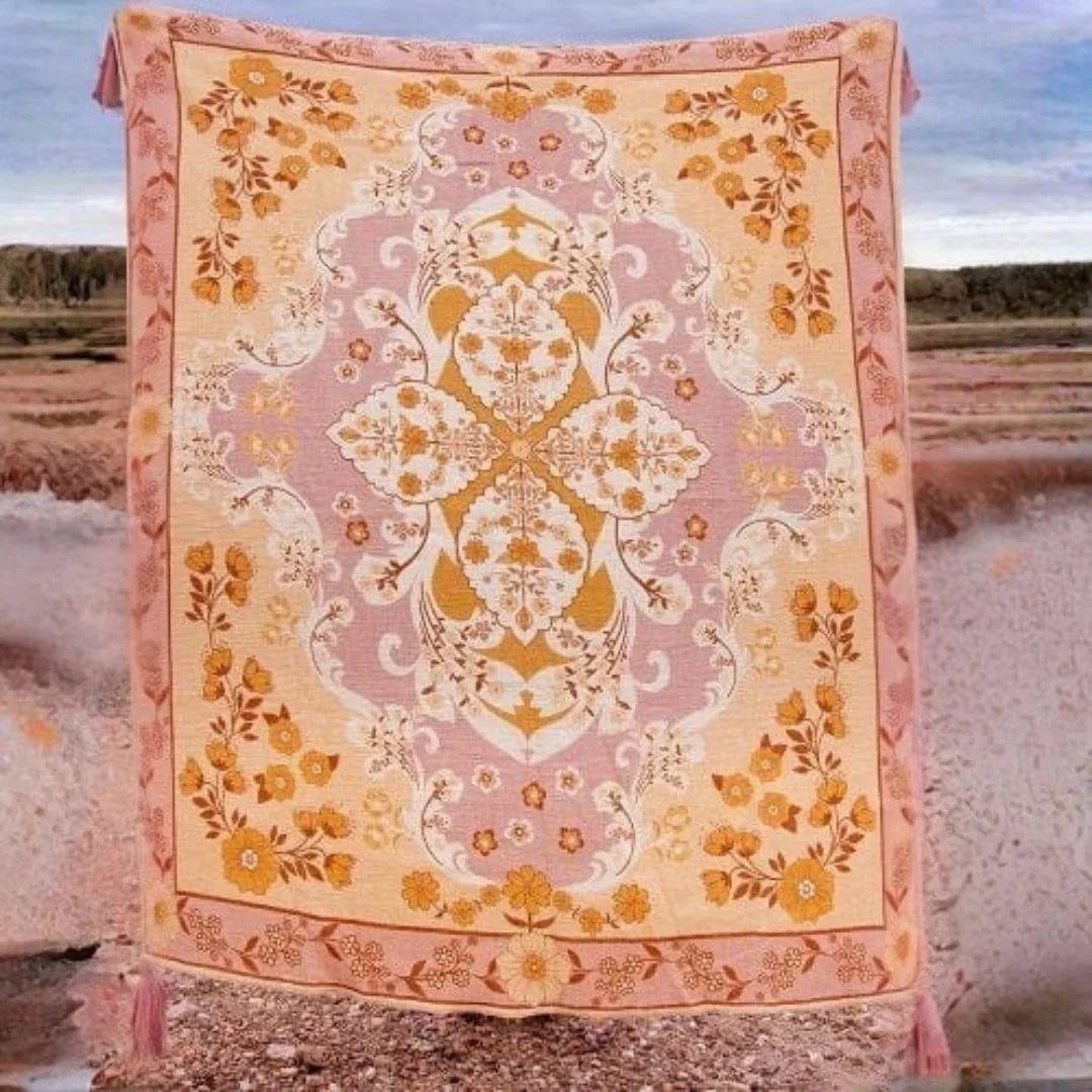 Decorative floral-patterned rug with pink and yellow colors on a desert background