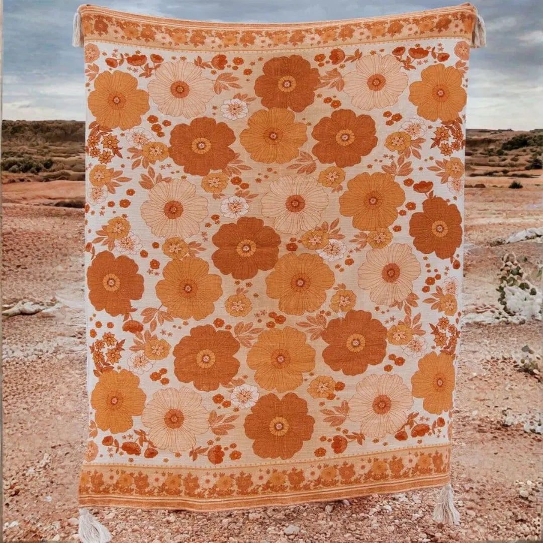 Floral patterned blanket with orange flowers on a desert background