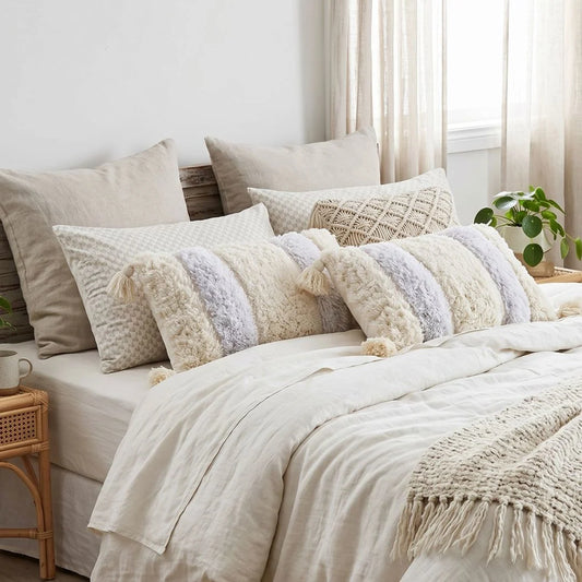 Neatly made bed with decorative pillows and a blanket in a cozy bedroom setting.