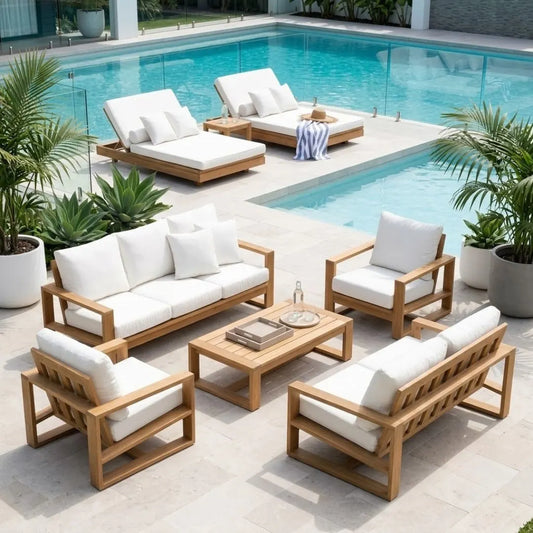 A 5-piece outdoor patio furniture set with a wooden frame and white cushions, arranged on a stone patio next to a swimming pool with potted plants.