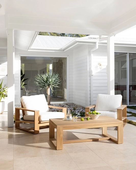 Outdoor patio set with wooden chairs and table on a tiled patio.