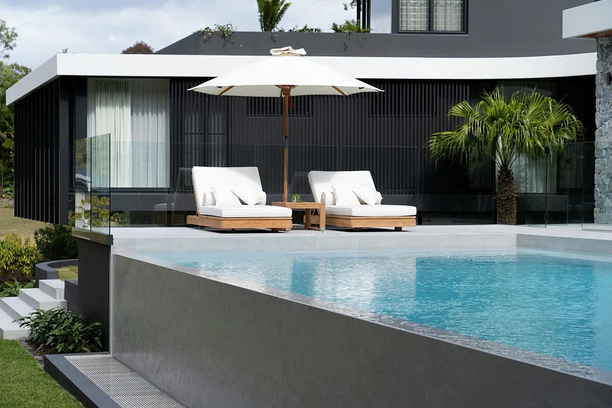 Modern house with a pool and lounge chairs on a sunny day
