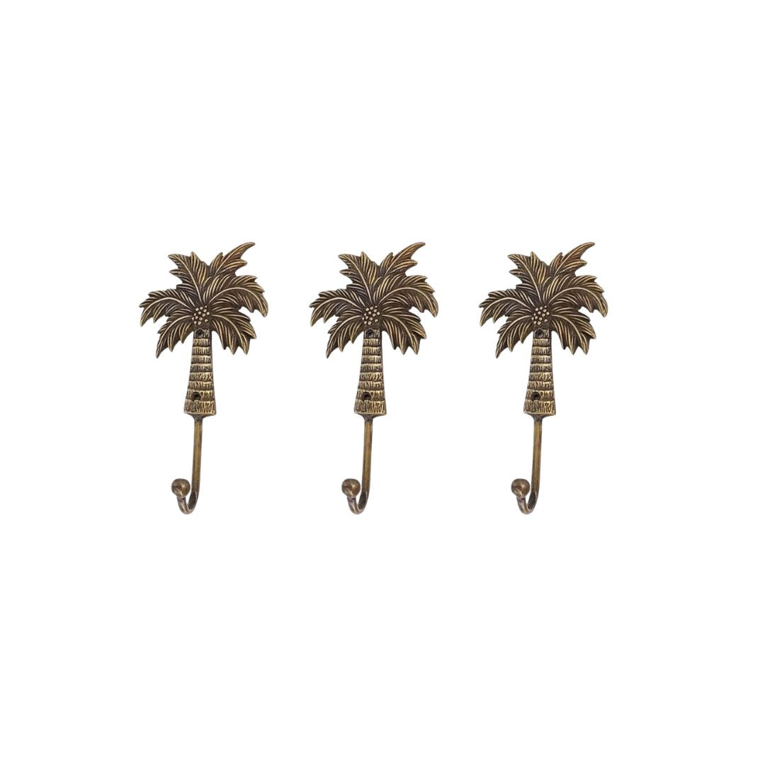 Three palm tree-shaped wall hooks on a white background