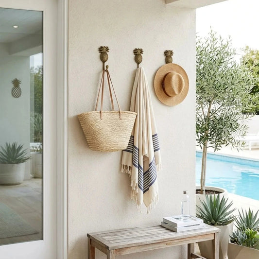 Wall hooks with a basket, towel, and hat in a room with a pool view.