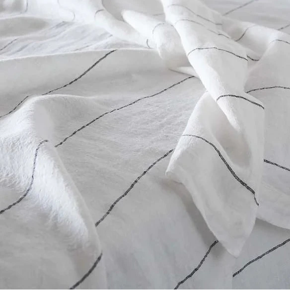White comforter with black stripes on a bed