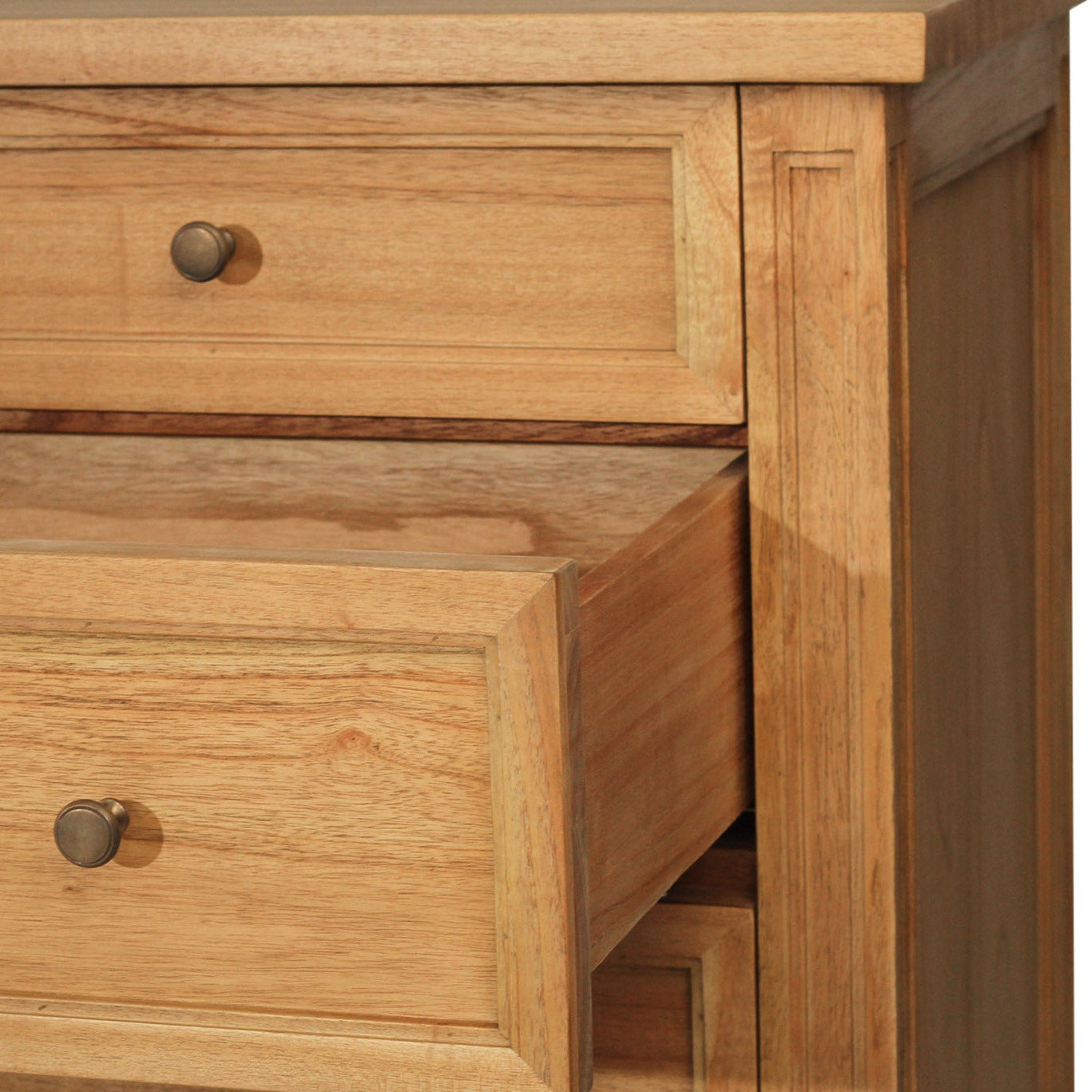 Close-up of a wooden drawer with a knob on a piece of furniture.
