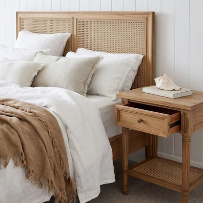 Bedroom with wooden bed and nightstand, white bedding, and a beige blanket.