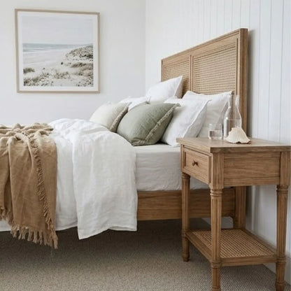 Bedroom with wooden bed and nightstand, white bedding, and a framed picture on the wall.