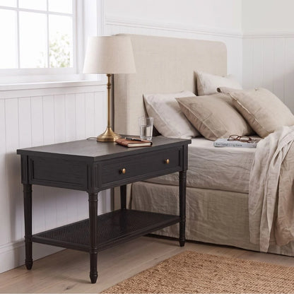 A black nightstand in a styled bedroom setting