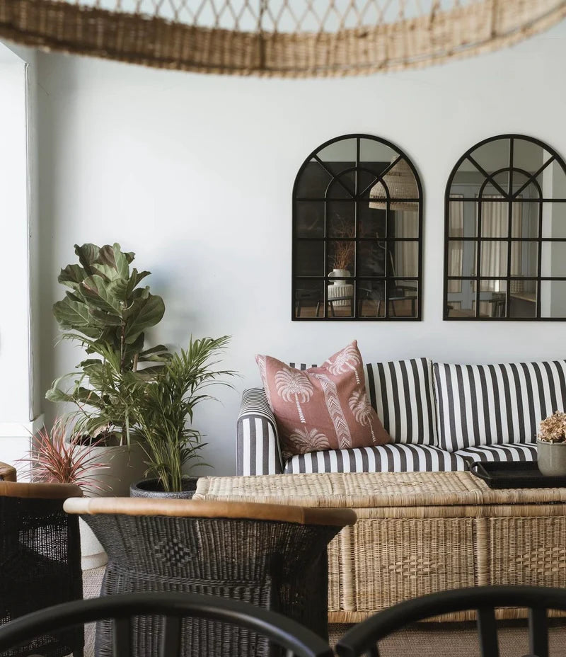 Living room with striped sofa, decorative pillows, and plants.