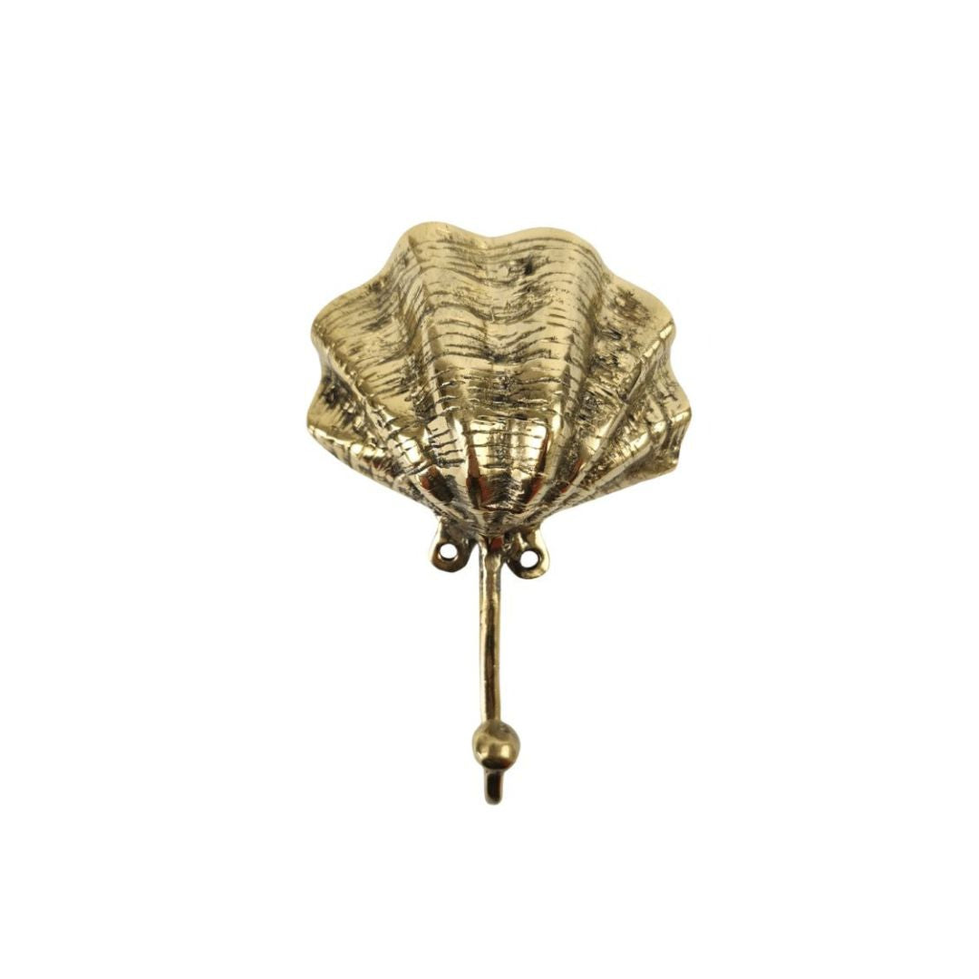 Gold shell-shaped brooch on a white background