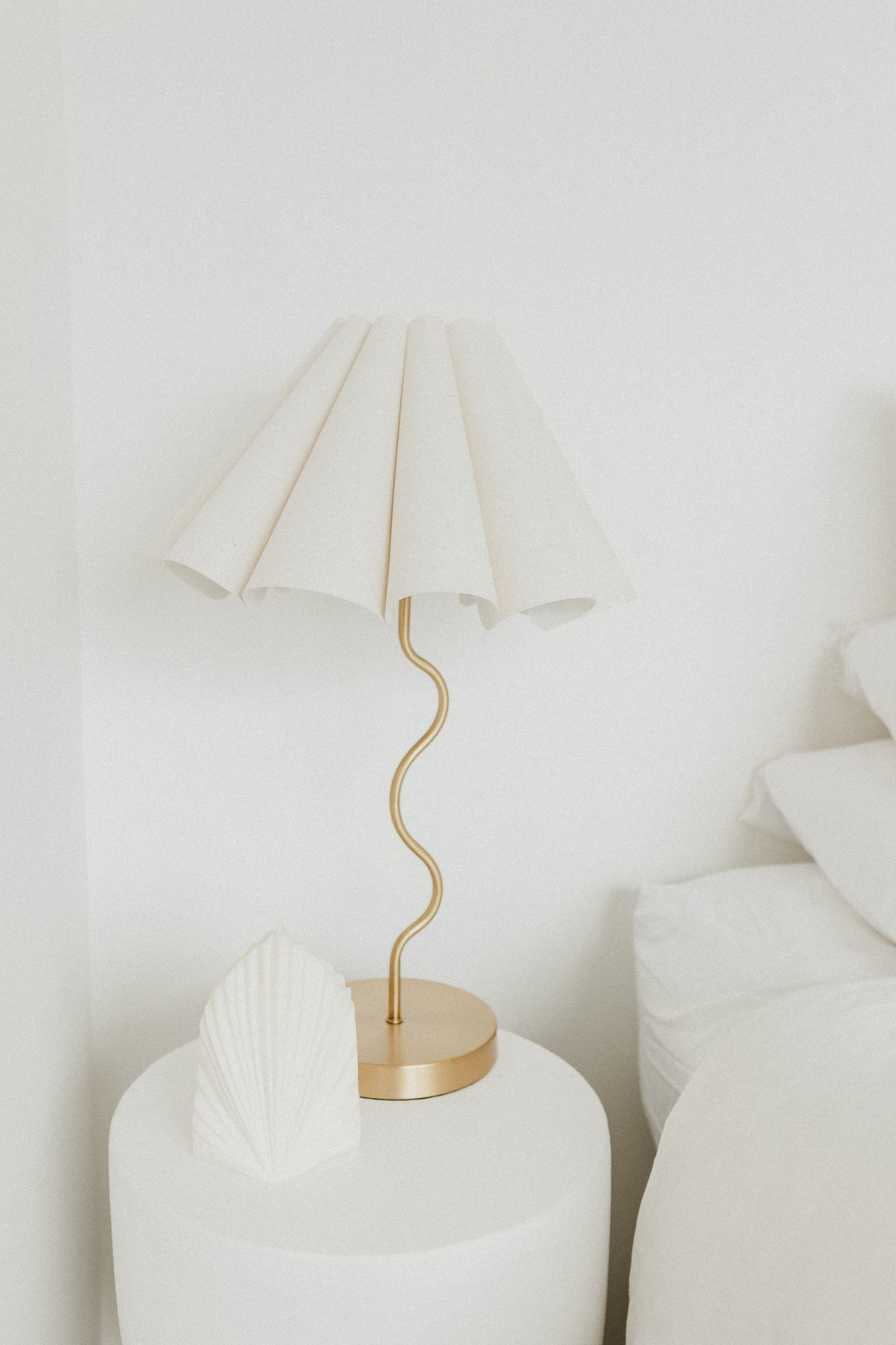 Cora Gold lamp with white shade on a white surface